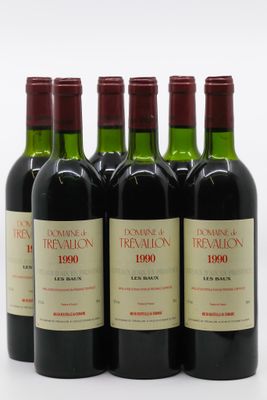 six bouteilles de vin rouge sont alignées sur une surface blanche