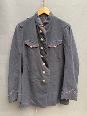 une vieille veste militaire accrochée au mur à côté d'un cintre en bois