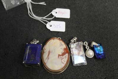 un collier sur lequel figure le portrait d'une femme, à côté d'autres objets