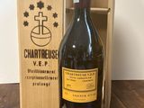 une bouteille de vin dans un coffret en bois, à côté d'un tire-bouchon