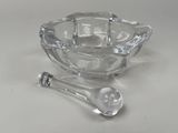 a glass bowl with a spoon and a spoon rest on a table