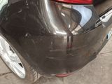 the rear end of a black car with a red tail light
