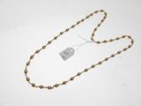 un gros plan d'un collier composé de perles dorées, orné d'une étiquette