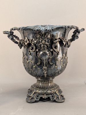a silver vase that is sitting on a table