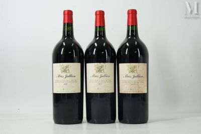 trois bouteilles de vin rouge posées sur une table blanche