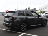 the bmw x3 is parked in a parking lot with other cars in the background