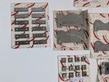 many pieces of paper that have been cut out on a table