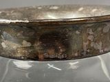 a silver bowl sitting on top of a glass table