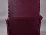 a burgundy velvet chair with gold legs and a buttoned back