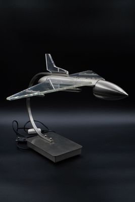 la maquette d'un avion de chasse est posée sur un socle