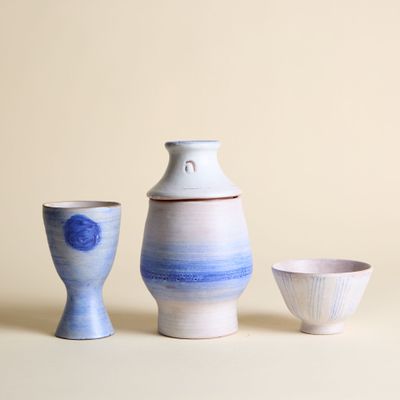 trois petits vases et un petit bol posés sur une table