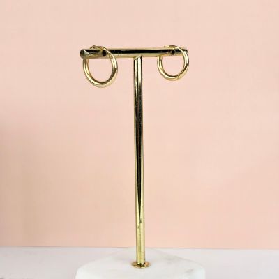 a white marble stand with two gold rings on top of it