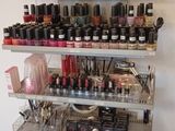 de nombreux flacons de vernis à ongles sur les étagères du salon