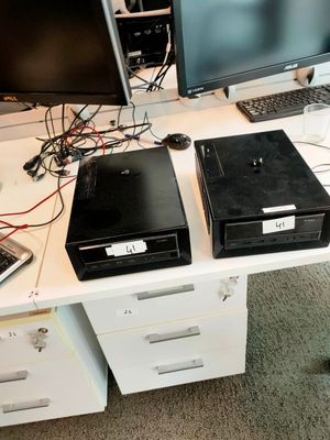 deux ordinateurs de bureau et un ordinateur portable posés sur un bureau blanc