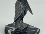 une image représentant une statue d'oiseau posée sur un socle en marbre