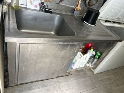 un évier en inox dans une cuisine équipée d'une cafetière