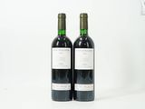 deux bouteilles de vin rouge posées l'une à côté de l'autre sur une surface blanche