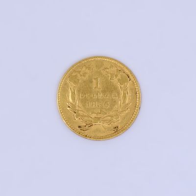 l'image d'une pièce d'or posée sur une surface blanche