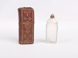 a small glass bottle next to a small glass bottle
