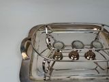 a silver tray with a silver handle on a white table