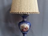 une image représentant une lampe bleue surmontée d'un abat-jour blanc