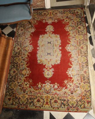 a rug on the floor in a room with a blue chair