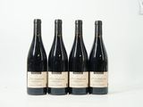 quatre bouteilles de vin sont alignées sur une surface blanche