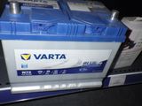 une batterie de voiture bleue et blanche posée sur une étagère