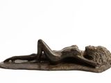 bronze sculpture of a woman laying on a leaf