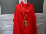 a mannequin wearing a red cape with a gold chain on it