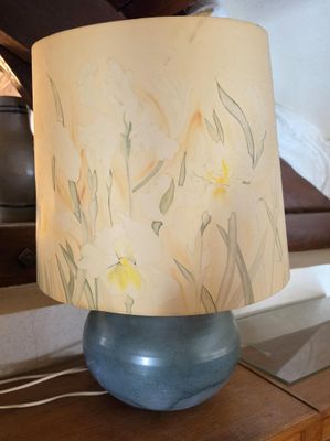 une lampe posée sur une table devant un lit
