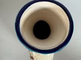 a blue and white vase sitting on a white table