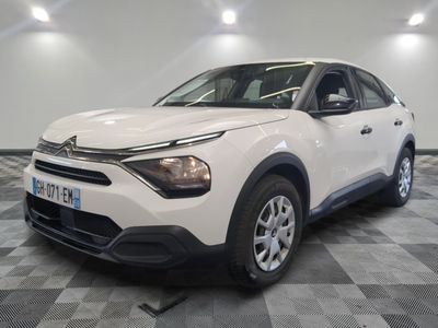 la voiture blanche est garée sur un sol en damier dans le garage