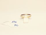 a gold ring on a white surface with a price tag
