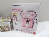 packaging of a pink coffee machine sitting on top of a white table