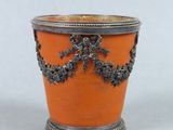un vase orange orné d'un motif argenté