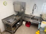 a kitchen with a sink, stove, and other items in it