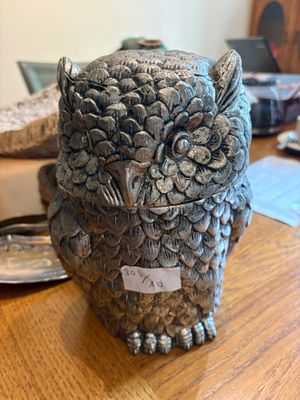 une statue représentant un hibou perché sur une table en bois
