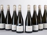 six bouteilles de vin sont alignées sur une table