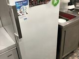 a white refrigerator in a small kitchen with a sink