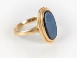 a close up of a gold ring with a blue stone