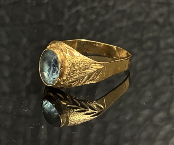 Bague en or 18 carats 750 millièmes à décor d’une pierre bleu ova...