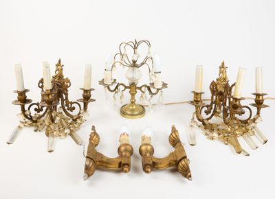 several brass and crystal chandeliers are arranged on a white surface