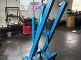 a close up of a blue scissor in a garage
