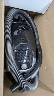 une boîte contenant un aspirateur et un tuyau