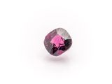 a close up of a pink diamond on a white surface