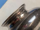 a silver pepper shaker sitting on top of a table