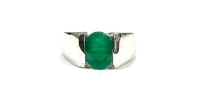 a close up of a ring with a green stone on it