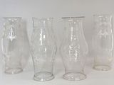 quatre vases en verre posés les uns à côté des autres sur une table