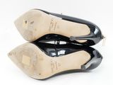 a pair of black high heels with a bow on the toe